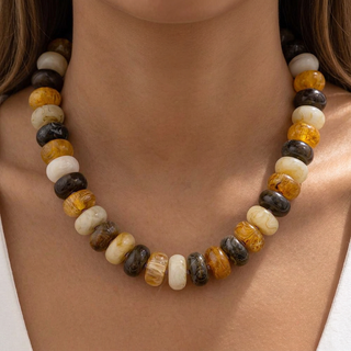 Model wearing the yellow, brown, and cream necklace